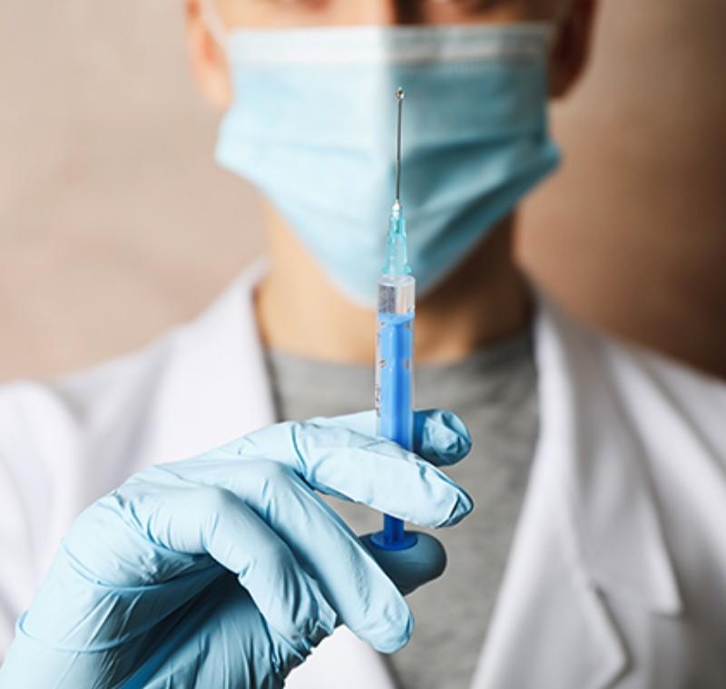 A person holding a syringe in their hand.